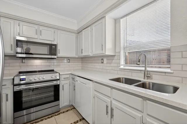 a kitchen with appliances a sink and cabinets