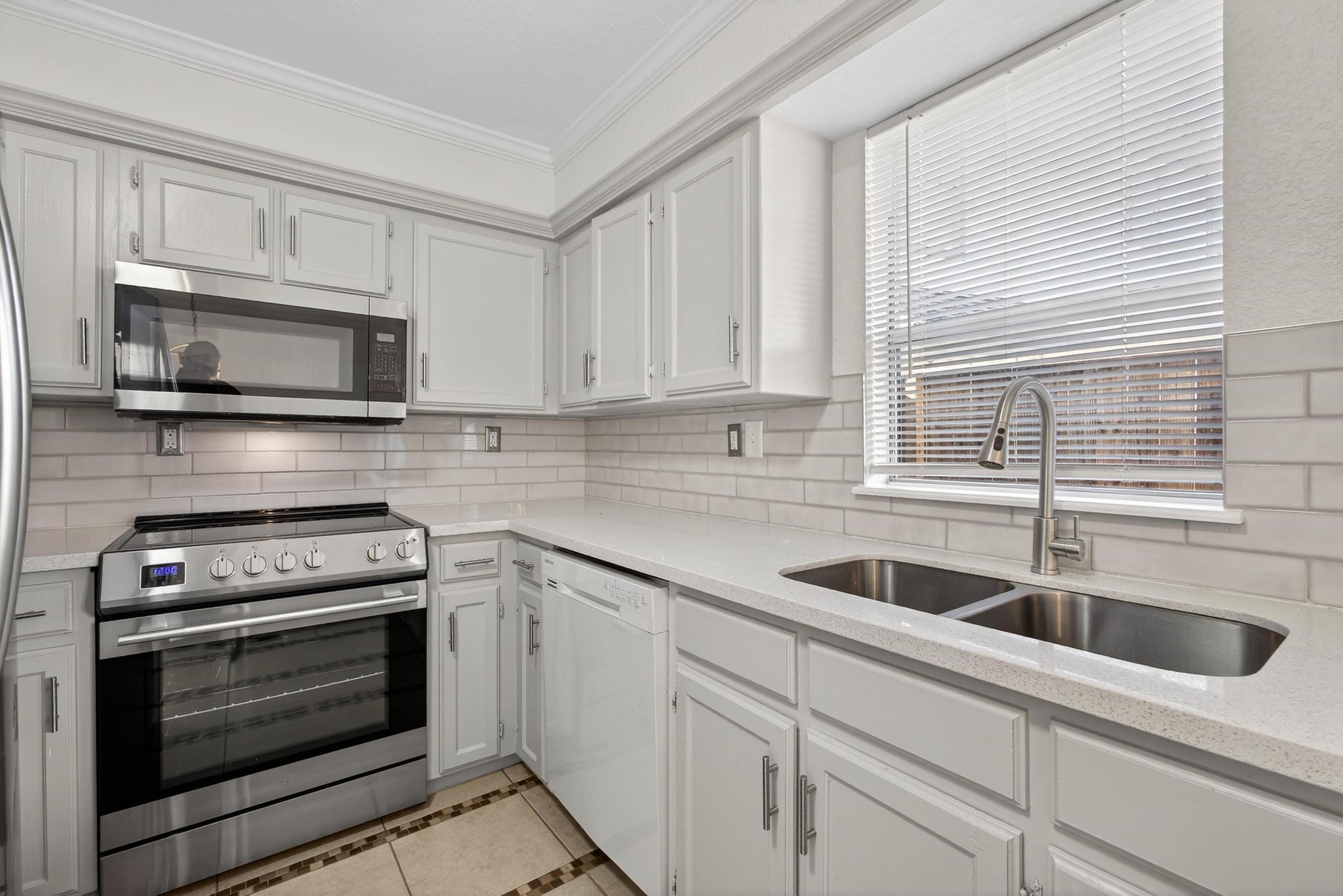 a kitchen with appliances a sink and cabinets