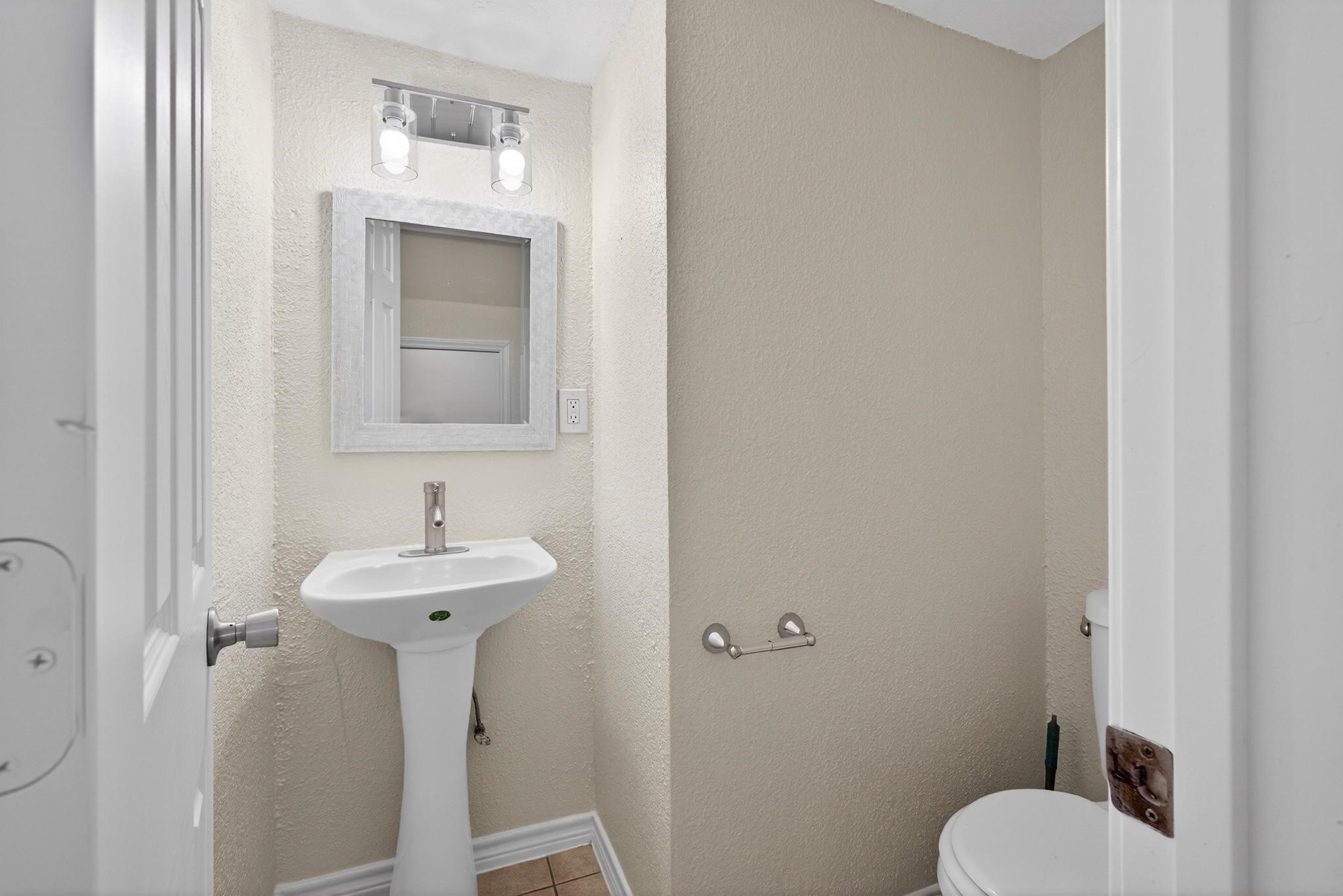 1221 Cedar Post Lane, Unit 1D Houston, TX 77055 - Photo 11 of 24 a bathroom with a toilet sink and mirror