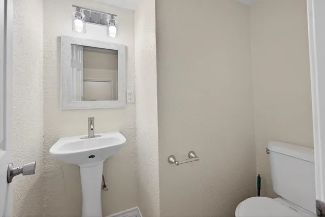 a bathroom with a toilet sink and mirror