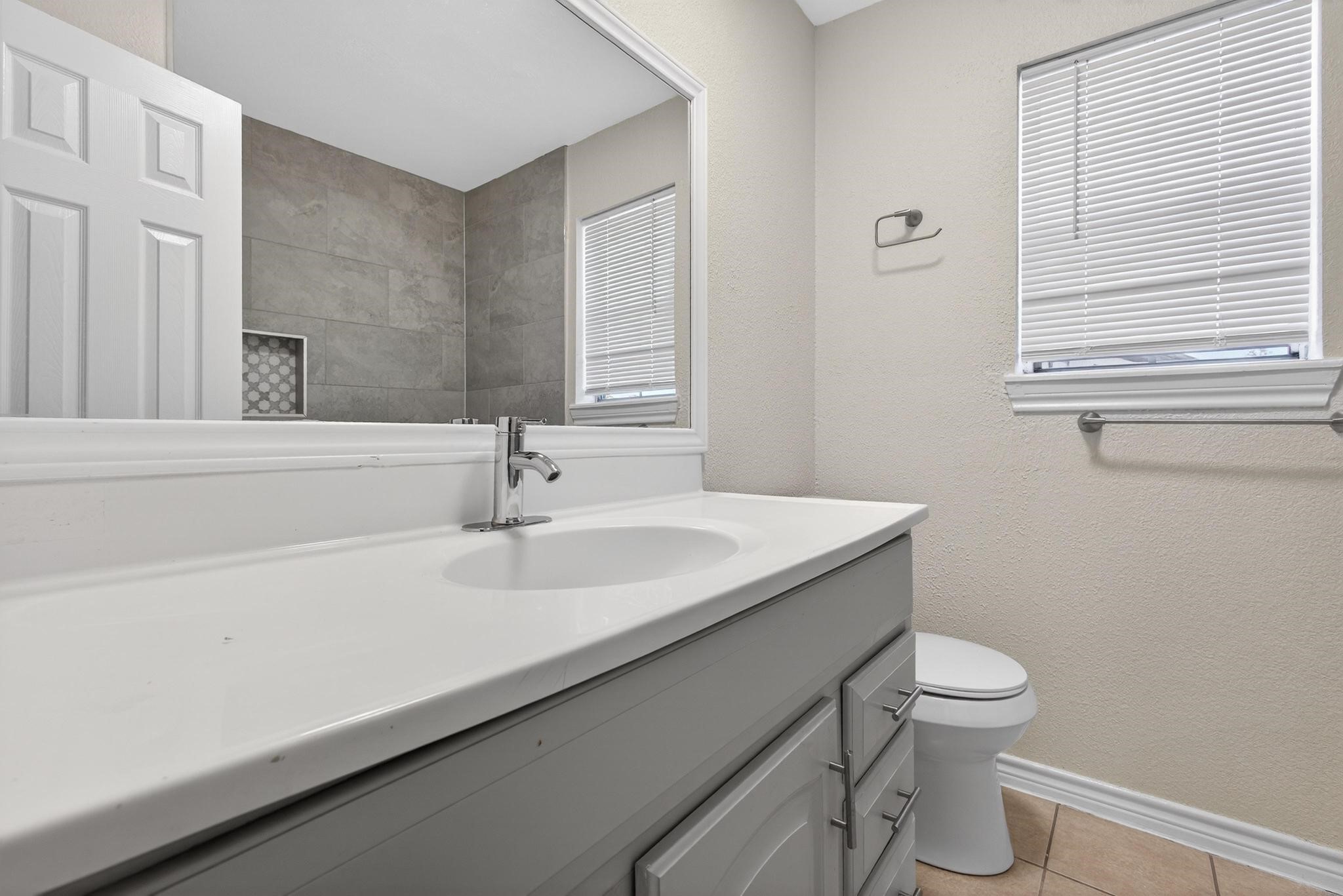 1221 Cedar Post Lane, Unit 1D Houston, TX 77055 - Photo 15 of 24 a bathroom with a sink a toilet and a mirror