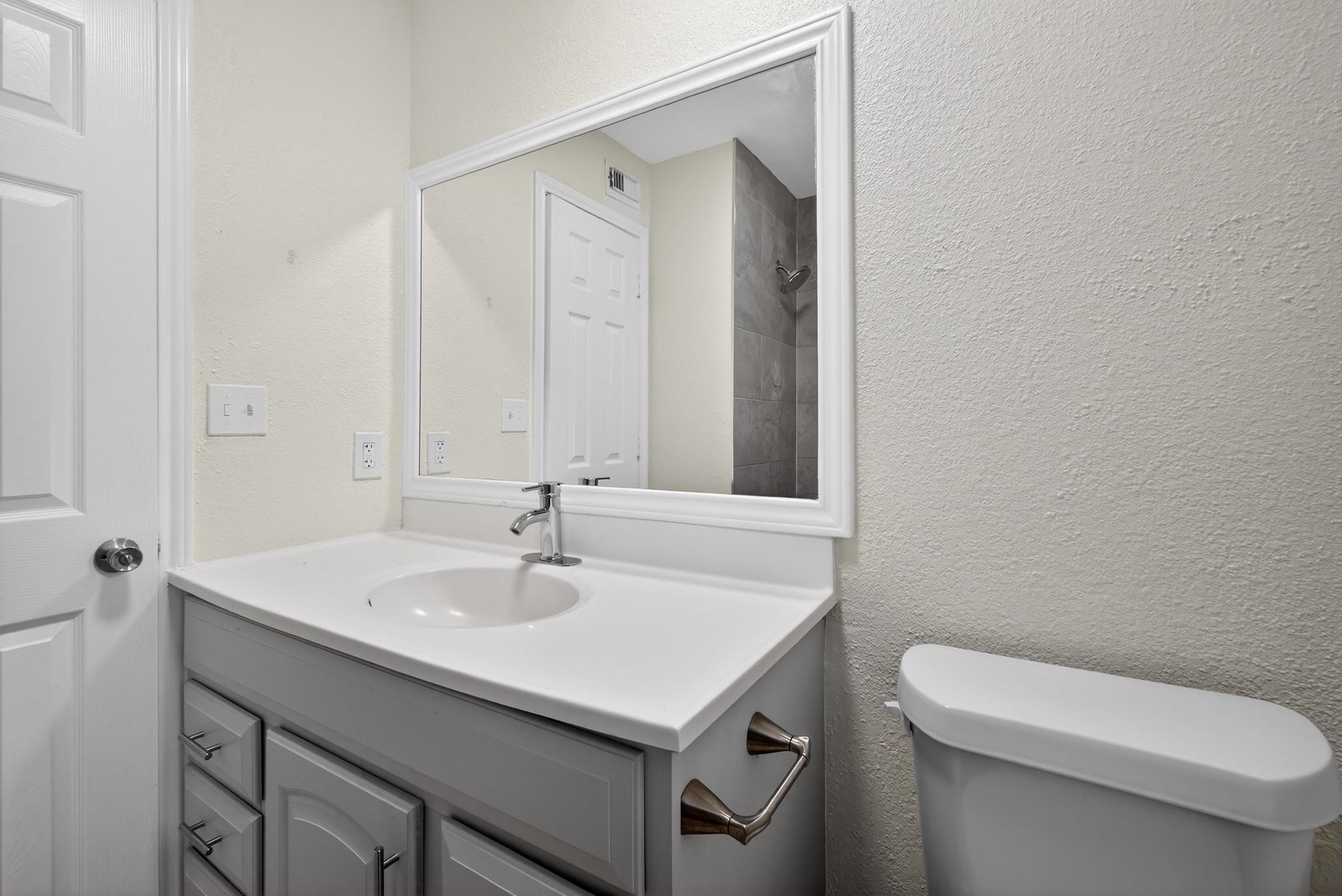 1221 Cedar Post Lane, Unit 1D Houston, TX 77055 - Photo 18 of 24 a bathroom with a sink a toilet and a mirror