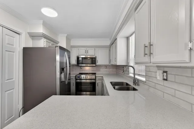 a kitchen with stainless steel appliances granite countertop a refrigerator sink and stove