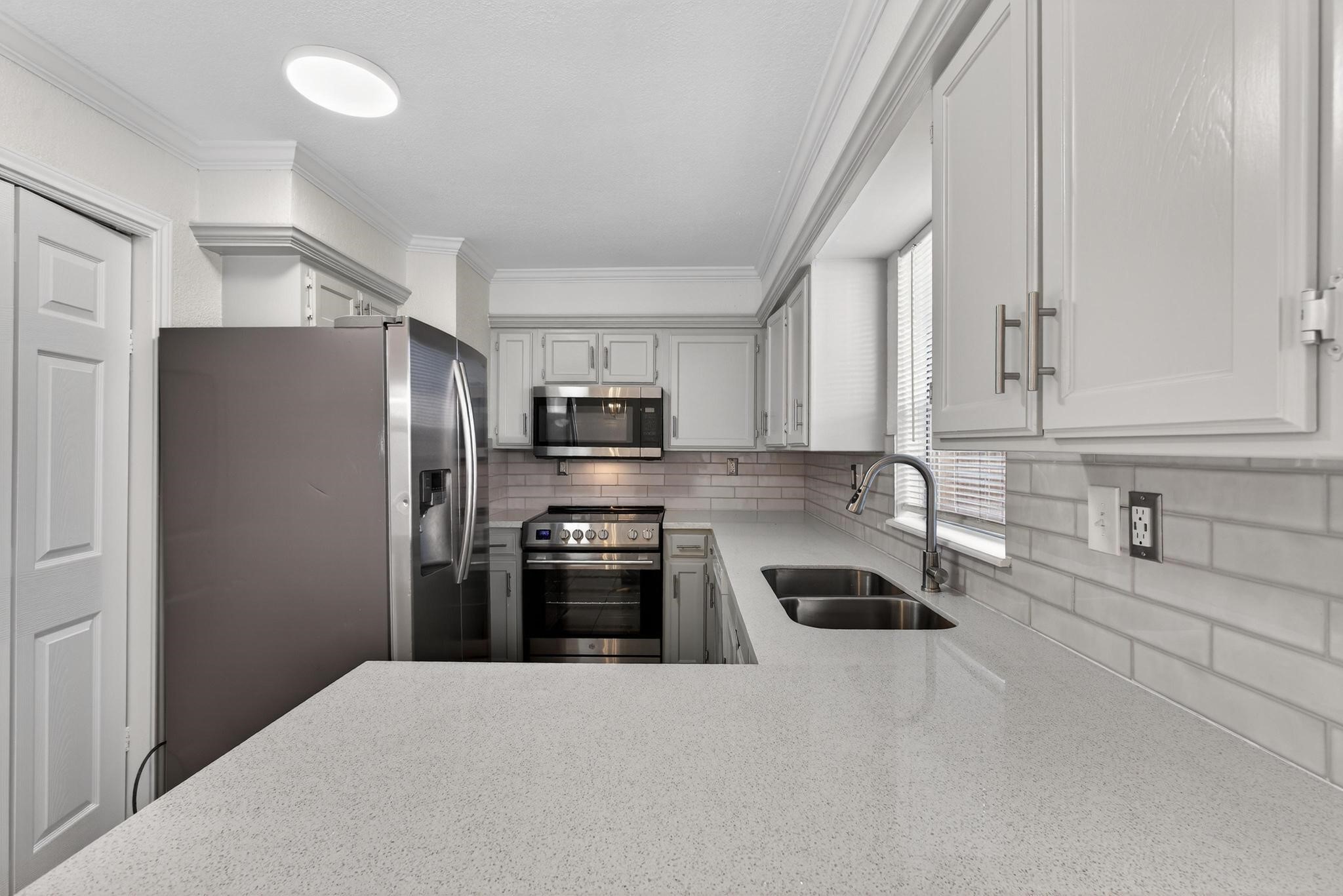 1221 Cedar Post Lane, Unit 1D Houston, TX 77055 - Photo 9 of 24 a kitchen with stainless steel appliances granite countertop a refrigerator sink and stove