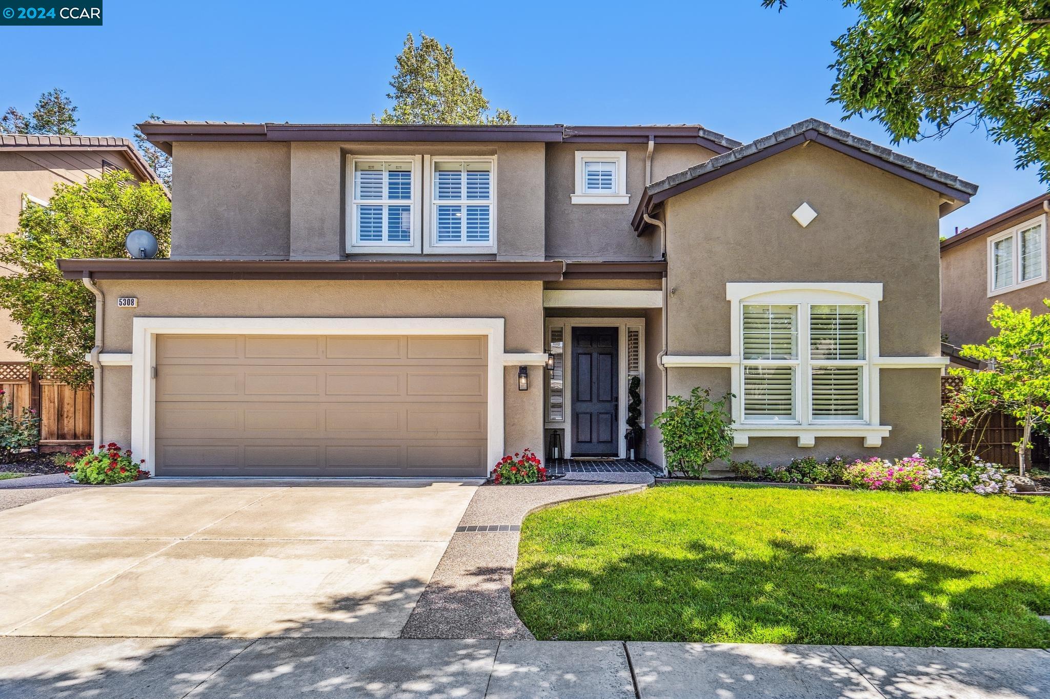 a front view of a house with a yard and garage