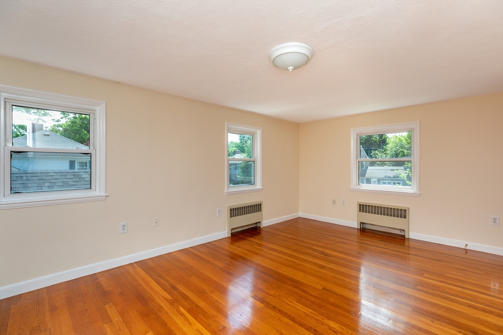 21 Allerton Road Milton, MA 02186 - Photo 15 of 42 a view of an empty room with wooden floor and a window