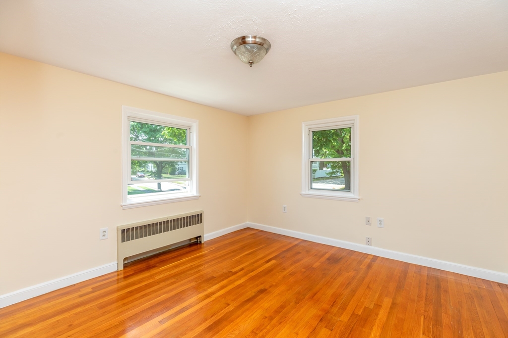 21 Allerton Road Milton, MA 02186 - Photo 20 of 42 a view of an empty room with wooden floor and a window