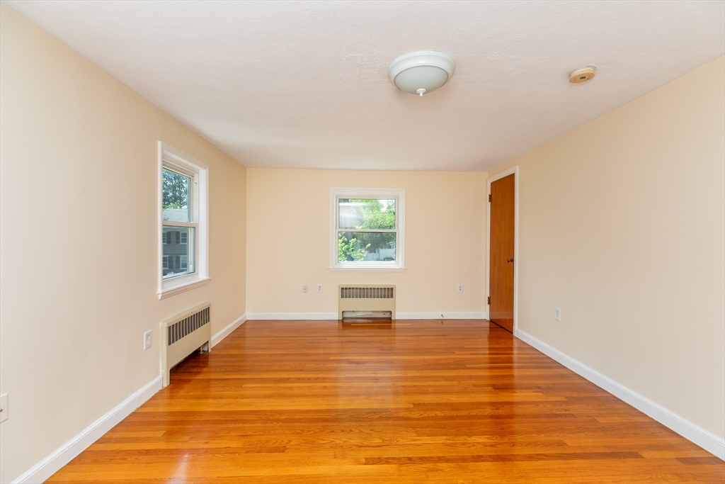 21 Allerton Road Milton, MA 02186 - Photo 22 of 42 a view of an empty room with wooden floor and a window