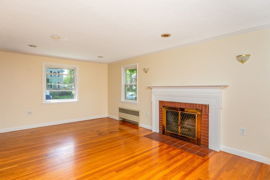 21 Allerton Road Milton, MA 02186 - Photo 4 of 42 a view of empty room with wooden floor and fireplace