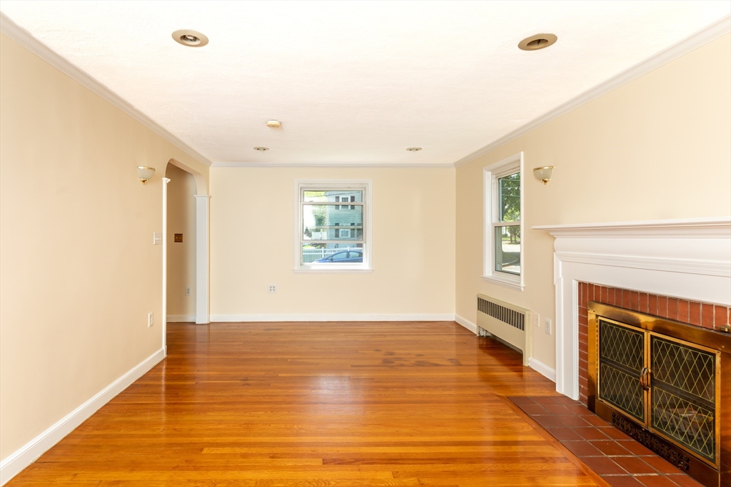 21 Allerton Road Milton, MA 02186 - Photo 7 of 42 a view of empty room with wooden floor and fireplace