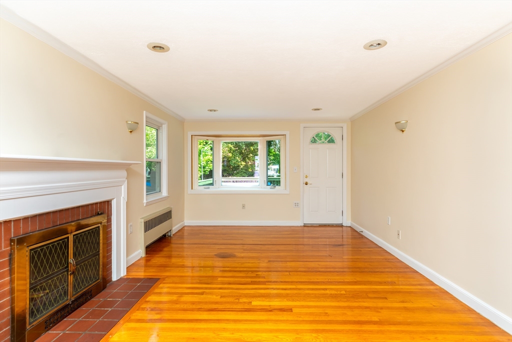 21 Allerton Road Milton, MA 02186 - Photo 8 of 42 a view of empty room with wooden floor and fireplace