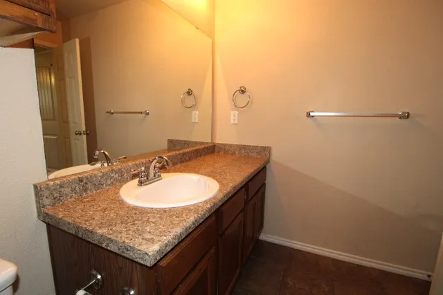 a bathroom with a granite countertop sink and a mirror