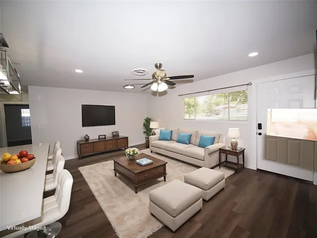 a living room with furniture a flat screen tv and a large window