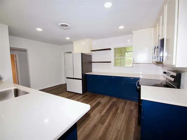 a kitchen with stainless steel appliances a sink and a refrigerator