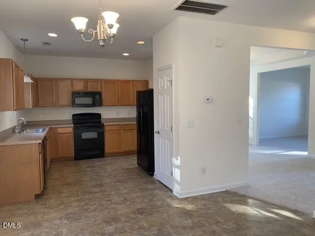 a kitchen with a sink stainless steel appliances cabinets and a window