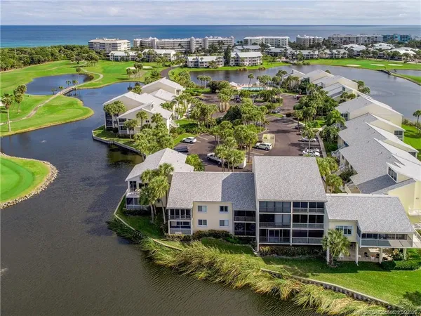 an aerial view of a house with a garden and lake view