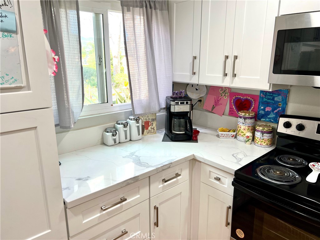a kitchen with stainless steel appliances a sink stove and cabinets