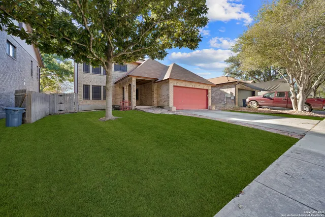 a front view of a house with a garden and trees