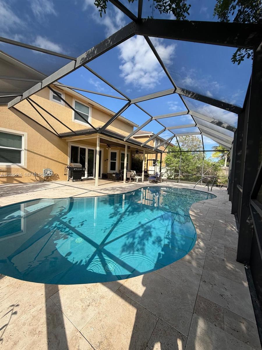 12680 Little Palm Lane Boca Raton, FL 33428 - Photo 9 of 13 a view of a backyard with table and chairs under an umbrella