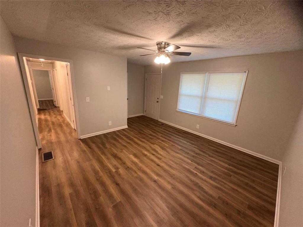 511 East Marable Street Monroe, GA 30656 - Photo 3 of 15 a view of an empty room with wooden floor and a ceiling fan