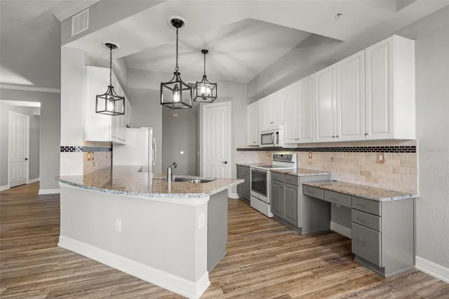 a kitchen with granite countertop white cabinets and stainless steel appliances