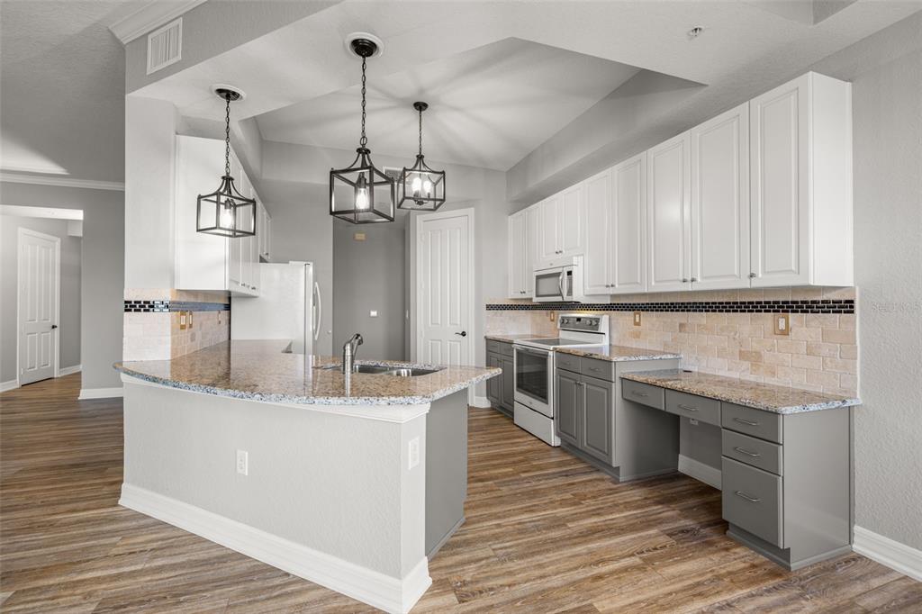99 Vivante Boulevard, Unit 305/9935 Punta Gorda, FL 33950 - Photo 12 of 73 a large kitchen with stainless steel appliances granite countertop a sink and dishwasher a stove with wooden floor