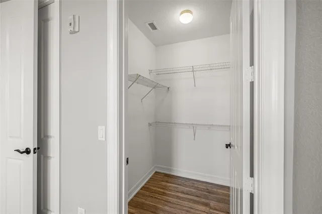 a view of a hallway with wooden floor and a balcony