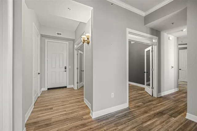 a view of an empty room with window and wooden floor