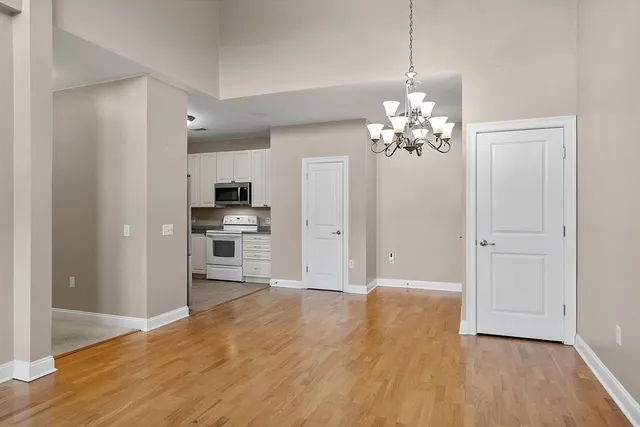 a view of a kitchen with refrigerator and wooden floor