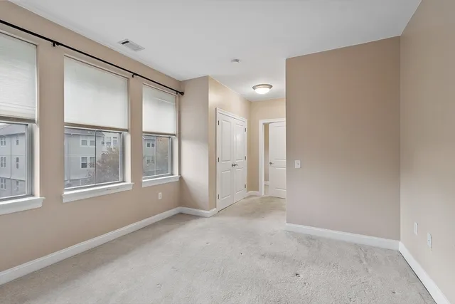 an empty room with windows and closet