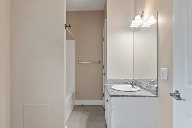 a bathroom with a granite countertop sink and a mirror
