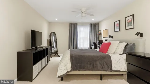 a living room with a bed furniture and a flat screen tv