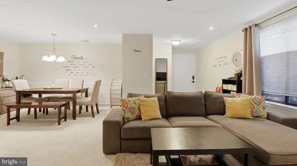 a living room with furniture a chandelier and a dining table