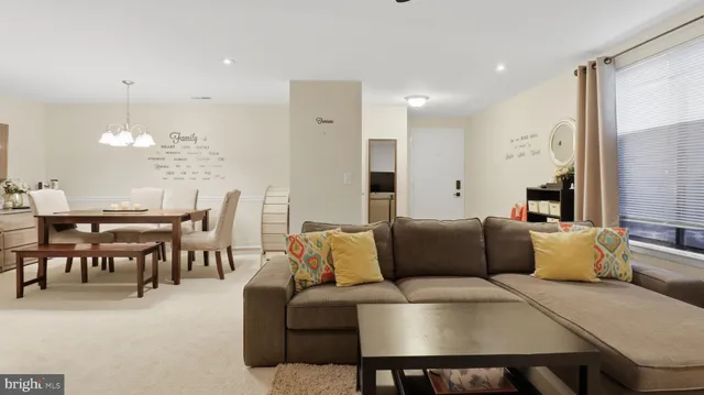 a living room with furniture a chandelier and a dining table