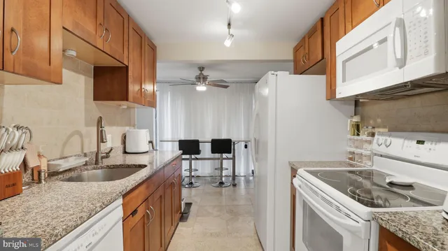 a kitchen with granite countertop a sink stove and cabinets
