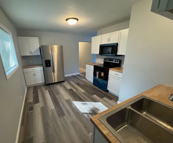 a view of kitchen with sink microwave and refrigerator