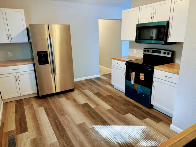 a kitchen with a refrigerator and a stove