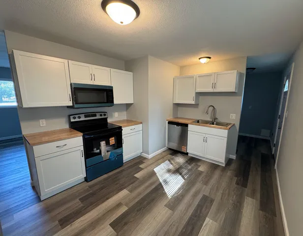 a kitchen with a sink cabinets and wooden floor