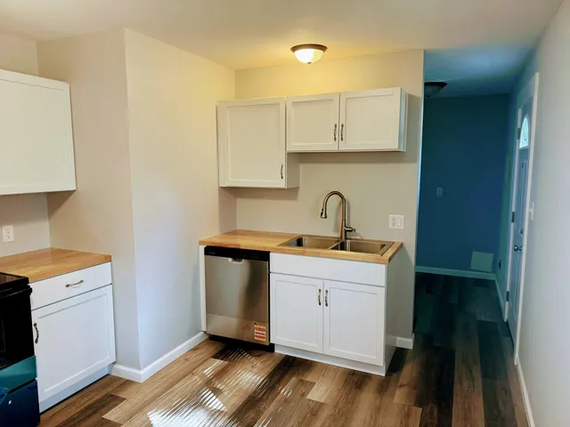 a room with a sink cabinets and wooden floor
