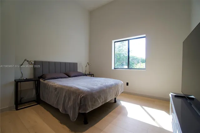 a spacious bedroom with a bed and a window