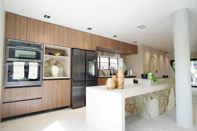 a kitchen with stainless steel appliances kitchen island granite countertop a refrigerator and a stove