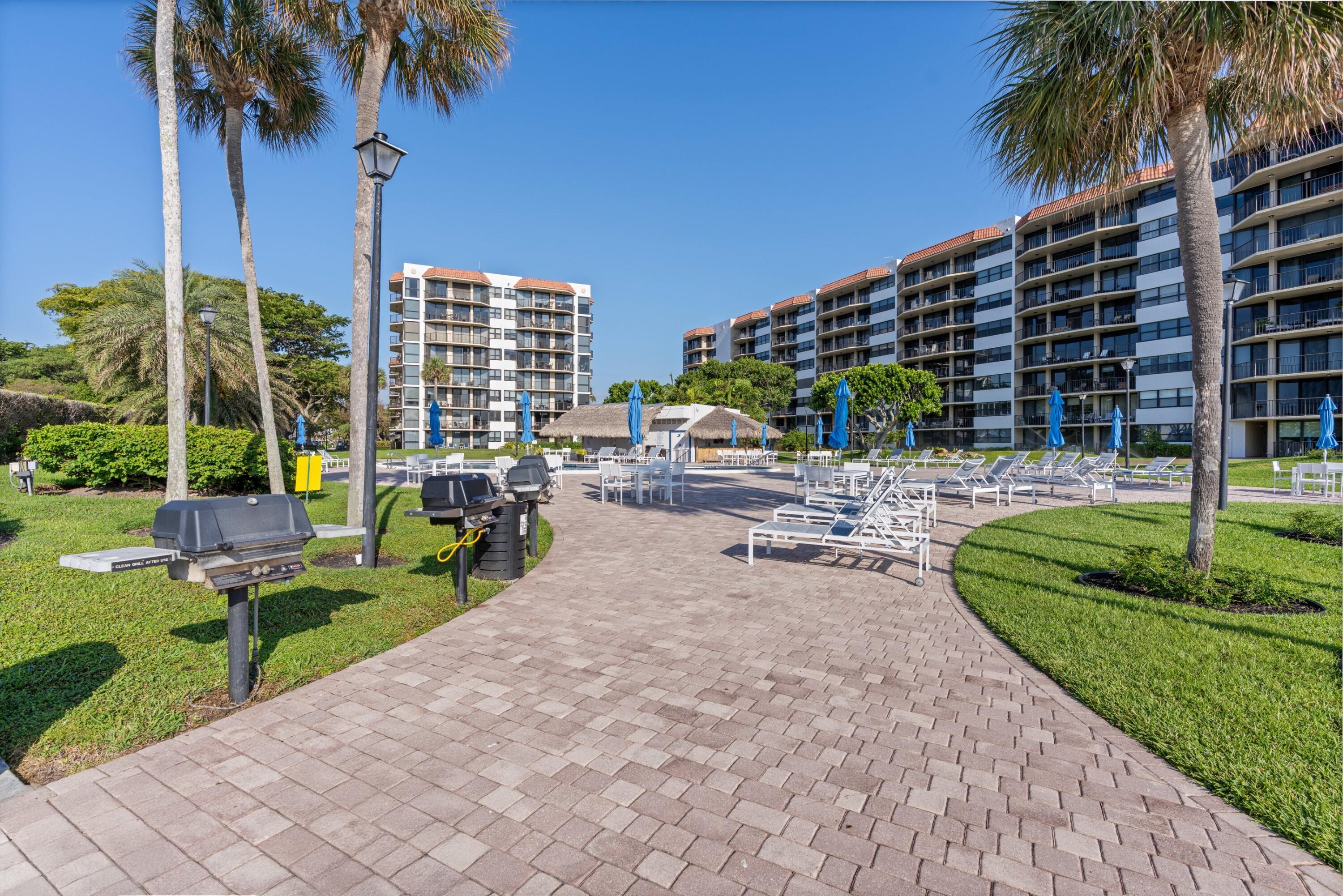 899 Jeffery Street, Unit 112 Boca Raton, FL 33487 - Photo 15 of 33 a row of palm trees and swimming pool in the back yard