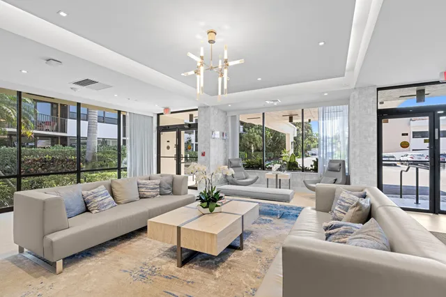 a living room with furniture potted plant and a large window