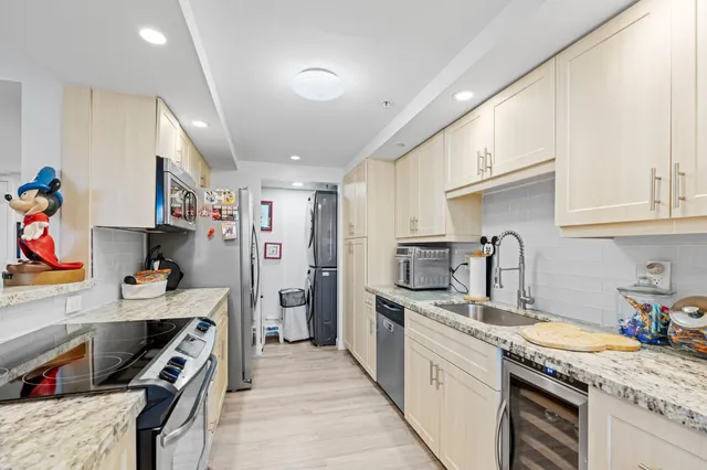 a kitchen with granite countertop a sink stove and refrigerator