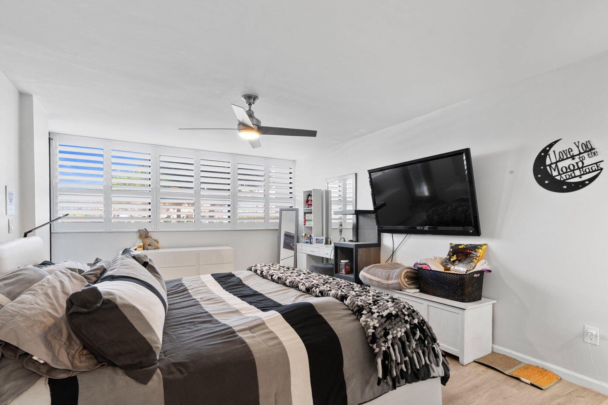 899 Jeffery Street, Unit 112 Boca Raton, FL 33487 - Photo 5 of 33 a bedroom with a bed and a flat screen tv