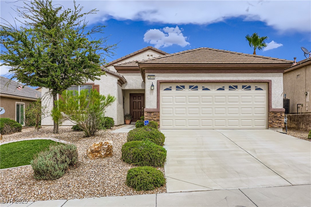 2610 Anani Road Henderson, NV 89044 - Photo 1 of 28 View of front of house with a tile roof, a garage, concrete driveway, and stucco siding