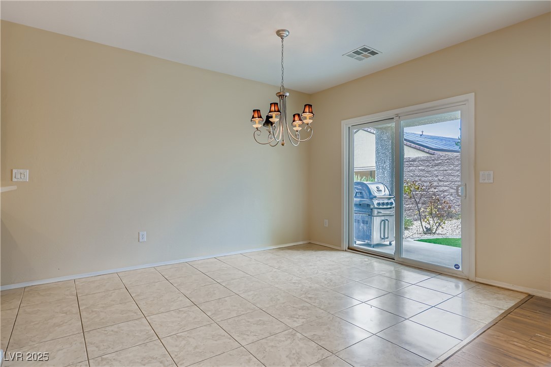 2610 Anani Road Henderson, NV 89044 - Photo 9 of 28 Empty room featuring a chandelier and light tile patterned floors