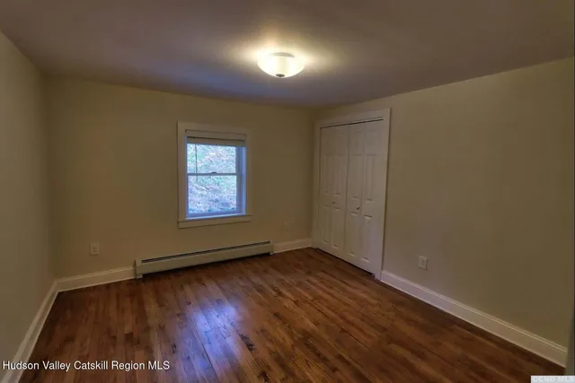 a view of an empty room with wooden floor