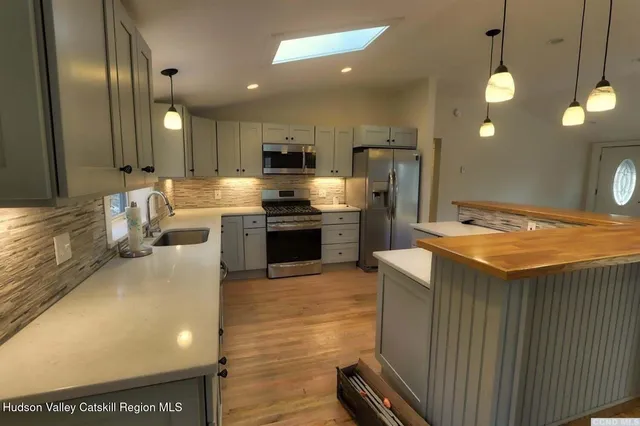 a kitchen with a table chairs refrigerator and microwave