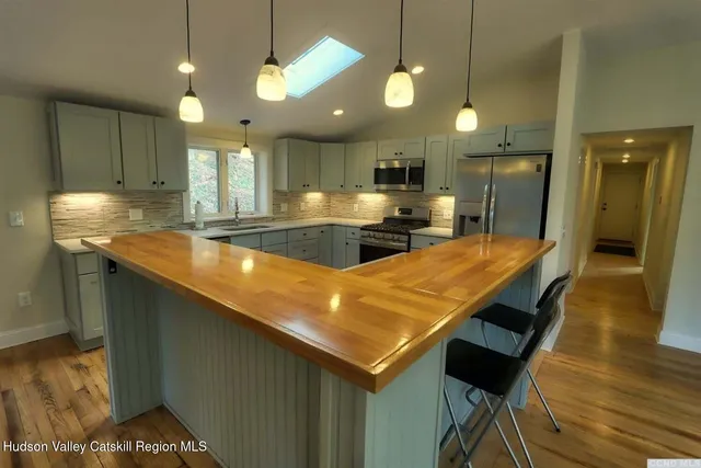 a kitchen with a table chairs refrigerator and microwave